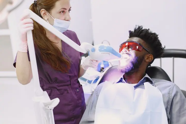 Professional teeth whitening with a whitening light in the dental chair
